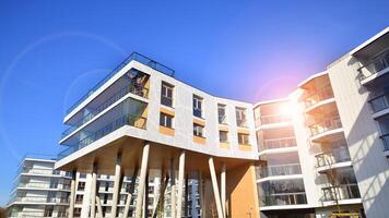 een appartement gebouw met een uniek bouwkundig oplossing. een modern woon- gebouw met een wit facade en staand Aan hoog beton pijlers. foto