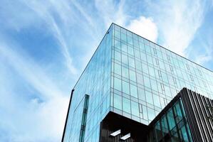 glas gebouw met transparant facade van de gebouw en blauw lucht. structureel glas muur reflecterend blauw lucht. abstract modern architectuur fragment. hedendaags bouwkundig achtergrond. foto