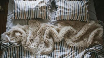 knus slaapkamer met gestreept linnen en een pluche beige deken, beeltenis comfort en ontspanning, geschikt voor concepten Leuk vinden huis interieur en winter gezelligheid foto