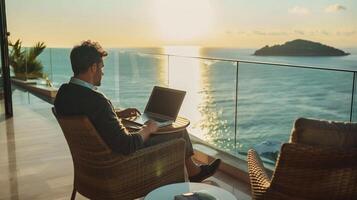 Mens werken Aan laptop Aan een zee visie balkon gedurende gouden uur, symboliseert afgelegen werk en werk leven evenwicht, mogelijk in de buurt de middellandse Zee foto