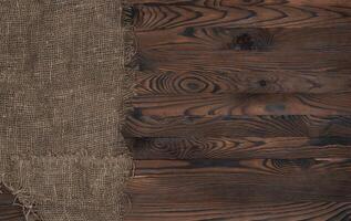 oud jute kleding stof servet Aan bruin houten achtergrond, top visie foto