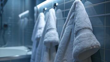 zacht pluizig handdoeken en een pluche badjas hangen Aan haken dichtbij klaar naar inpakken de persoon in warmte en comfort na hun bad foto