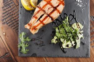 zalm vis steak met citroen en greens foto