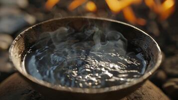 een kom van water met essentieel oliën stomen Aan de heet kolen creëren een rustgevend en vredig atmosfeer. foto