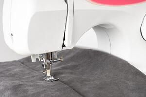 modern naaien machine met grijs kleding stof foto