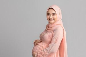 stralend verwachtend moeder in zacht roze hijab omarmen moederschap foto