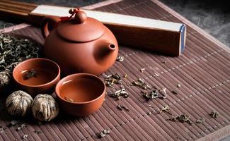 Aziatische theepot met kopjes en groene thee op houten placemat kopie ruimte foto