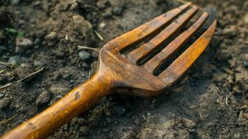 een detailopname van een prachtig bewerkte houten tuin vork met een glad gepolijst oppervlakte perfect voor losmaken bodem en beluchten de land- foto