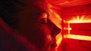 de rood gloed van de sauna reflecterend uit de zweet Aan een reizigers gezicht signalering de vrijlating van gifstoffen en spanning. foto