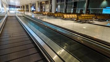 leeg luchthaven terminal met een in beweging loopbrug en aan het wachten Oppervlakte, presentatie van modern reizen infrastructuur, geschikt voor bedrijf en vakantie reizen thema's foto