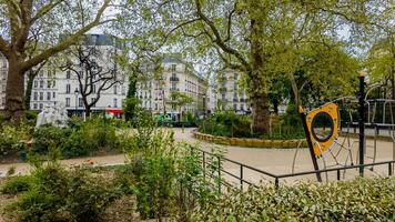 rustig stedelijk park in voorjaar met speelplaats uitrusting en weelderig groen, ideaal voor thema's van stad leven, natuur in stedelijk instellingen, en openbaar parken foto
