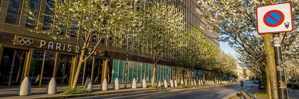 bloeiende voorjaar bomen lijn de straat door de olympisch ringen versierd Parijs 2024 kantoor, met een Nee parkeren teken, Parijs, Frankrijk, april 14e, 2024 foto