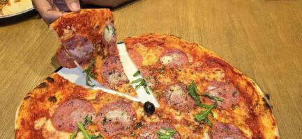 vers gebakken nieuw york stijl pizza met gesmolten Mozzarella kaas en baseren tomaat saus met veel van peperoni foto