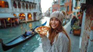 jong vrouw genieten van pizza in toneel- Venetië door de kanaal foto