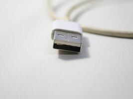 dichtbij omhoog de wit gebroken smartphone USB kabel Aan wit houten achtergrond. foto