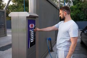 Bij een betaling machine een Mens pays naar wassen zijn auto. een auto Bij een zelf onderhoud auto wassen. foto