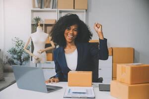 opstarten mkb-ondernemer van freelance aziatische vrouw met behulp van een laptop met doos vrolijk succes aziatische vrouw haar hand tilt online marketing op verpakkingsdoos en levering mkb-ideeconcept foto