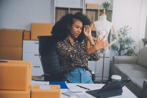 opstarten mkb-ondernemer van freelance aziatische vrouw met behulp van een laptop met doos vrolijk succes aziatische vrouw haar hand tilt online marketing op verpakkingsdoos en levering mkb-ideeconcept foto