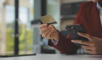 hand- Holding credit kaart en gebruik makend van laptop. zakenvrouw of ondernemer werken van huis. online winkelen, e-commerce, internet bankieren, uitgeven geld, werk van huis concept foto