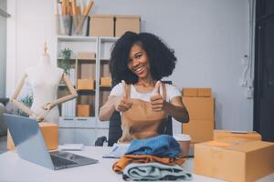 opstarten mkb klein bedrijf ondernemer van freelance Aziatisch vrouw vervelend schort gebruik makend van laptop en doos naar te ontvangen en recensie bestellingen online naar bereiden naar pak verkopen naar klanten, online mkb bedrijf ideeën. foto