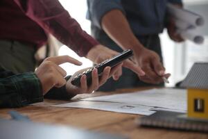 verschillend team van specialisten gebruik laptop Aan bouw plaats. echt landgoed gebouw project met ingenieur investeerder en zakenman controle Oppervlakte, werken Aan civiel engineering, bespreken strategie plan foto