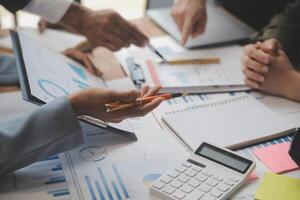 co-werkconferentie, zakelijke teamvergadering aanwezig, investeerderscollega's bespreken nieuw plan financiële grafiekgegevens op kantoortafel met laptop en digitale tablet, financiën, boekhouding, investeringen. foto