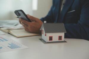 zakenlieden Holding pennen, ondertekening huis titels met verzekering, zorg over echt landgoed Diensten en de idee van echt landgoed agenten aanbieden interesseren in termijnen naar hun klanten. foto