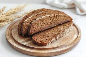 geheel tarwe brood brood Aan snijdend bord. foto