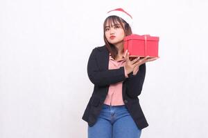 mooi Aziatisch meisje in pak glimlachen met de kerstman claus hoed poseren met Kerstmis geschenk doos geschenk en hijs- doos en zoenen Aan wit achtergrond voor Promotie, reclame, banier, aanplakbord foto
