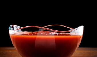 ketchup in een glas kop Aan een houten bord. foto