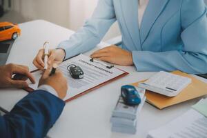 verzekering officieren hand- over- de auto sleutels na de huurder. hebben ondertekend een auto verzekering document of een huren of overeenkomst document buying of verkoop een nieuw of gebruikt auto met een auto foto