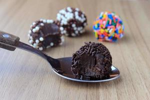 brigadeiro, brigadier, zoete chocolade typisch voor de Braziliaanse keuken bedekt met deeltjes, op een houten achtergrond. foto