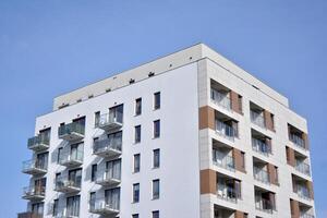 modern appartement gebouwen Aan een zonnig dag met een blauw lucht. facade van een modern appartement gebouw. glas oppervlakte met zonlicht. foto