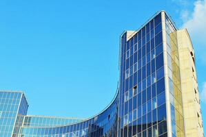 structureel glas muur reflecterend blauw lucht. abstract modern architectuur fragment foto