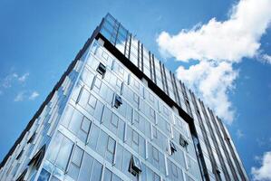 glas gebouw met transparant facade van de gebouw en blauw lucht. structureel glas muur reflecterend blauw lucht. abstract modern architectuur fragment. hedendaags bouwkundig achtergrond. foto