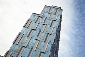 glas gebouw met transparant facade van de gebouw en blauw lucht. structureel glas muur reflecterend blauw lucht. abstract modern architectuur fragment. hedendaags bouwkundig achtergrond. foto