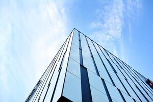 glas gebouw met transparant facade van de gebouw en blauw lucht. structureel glas muur reflecterend blauw lucht. abstract modern architectuur fragment. hedendaags bouwkundig achtergrond. foto