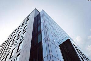 glas gebouw met transparant facade van de gebouw en blauw lucht. structureel glas muur reflecterend blauw lucht. abstract modern architectuur fragment. hedendaags bouwkundig achtergrond. foto