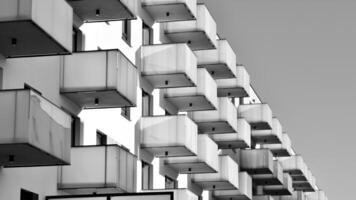 fragment van de gebouwen facade met ramen en balkons. modern appartement gebouwen Aan een zonnig dag. facade van een modern woon- gebouw. zwart en wit. foto