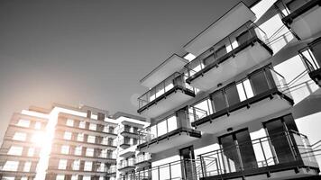 fragment van een facade van een gebouw met ramen en balkons. modern appartement gebouwen Aan een zonnig dag. facade van een modern appartement gebouw. zwart en wit. foto