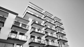 fragment van een facade van een gebouw met ramen en balkons. modern appartement gebouwen Aan een zonnig dag. facade van een modern appartement gebouw. zwart en wit. foto
