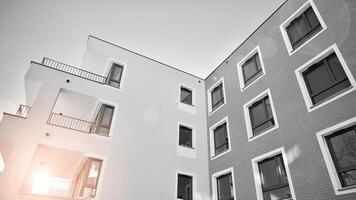 fragment van een facade van een gebouw met ramen en balkons. modern appartement gebouwen Aan een zonnig dag. facade van een modern appartement gebouw. zwart en wit. foto