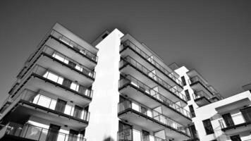 fragment van een facade van een gebouw met ramen en balkons. modern appartement gebouwen Aan een zonnig dag. facade van een modern appartement gebouw. zwart en wit. foto