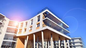 een appartement gebouw met een uniek bouwkundig oplossing. een modern woon- gebouw met een wit facade en staand Aan hoog beton pijlers. foto