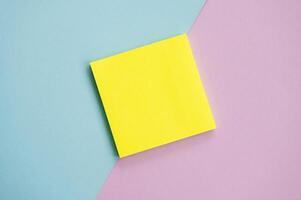 top visie van geel lakens stickers Aan een blauw en Purper achtergrond mockup met een notitieboekje , lakens voor aantekeningen foto
