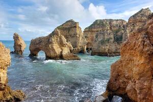 rotsachtig zee bogen Bij Algarve kust foto