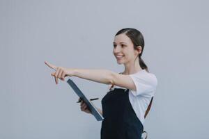 vrolijk mooi Aziatisch vrouw vervelend jeans overall met opgewonden aan het doen winnaar gebaar met armen verheven geïsoleerd Aan wit achtergrond. foto