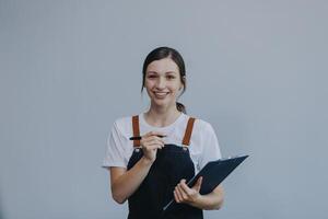 vrolijk mooi Aziatisch vrouw vervelend jeans overall met opgewonden aan het doen winnaar gebaar met armen verheven geïsoleerd Aan wit achtergrond. foto