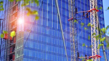 hoog stijgen gebouw onder bouw. installatie van glas facade panelen Aan een versterkt beton structuur. foto