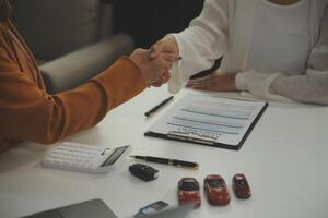 verzekering officieren hand- over- de auto sleutels na de huurder. hebben ondertekend een auto verzekering document of een huren of overeenkomst document buying of verkoop een nieuw of gebruikt auto met een auto foto